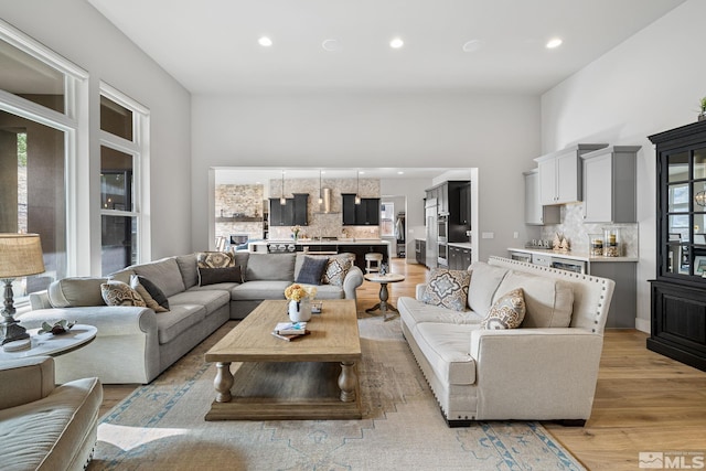 living area with light wood-style floors and recessed lighting