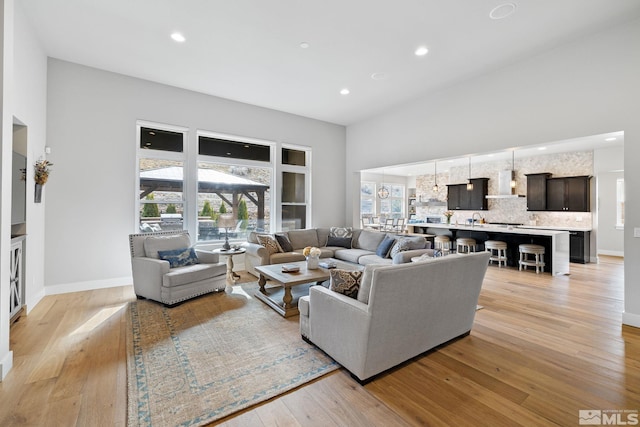 living area with recessed lighting, baseboards, and light wood finished floors