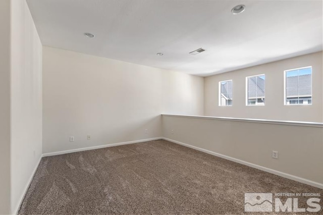 carpeted empty room featuring visible vents and baseboards