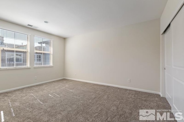 unfurnished bedroom featuring carpet flooring, visible vents, and baseboards