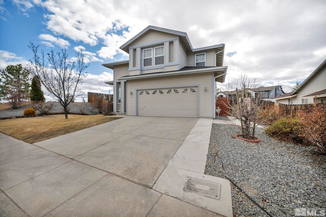 traditional-style home with a garage, fence, and concrete driveway