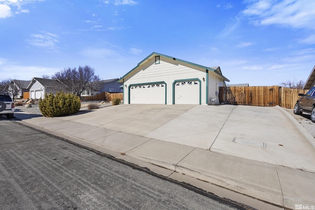 view of front of home with a garage, fence, and concrete driveway