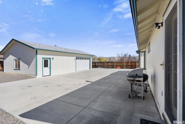 exterior space featuring a garage, area for grilling, and fence