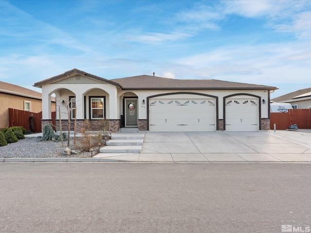 view of front of home with driveway, an attached garage, fence, and stucco siding