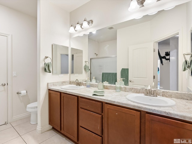 full bath featuring a stall shower, a sink, toilet, and tile patterned floors