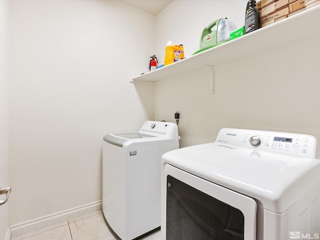 washroom with laundry area, washer and clothes dryer, and baseboards