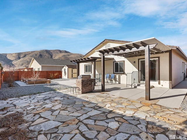 rear view of property featuring a fenced backyard, an outdoor structure, a pergola, a storage unit, and stucco siding