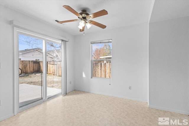 empty room featuring baseboards, a wealth of natural light, and tile patterned floors