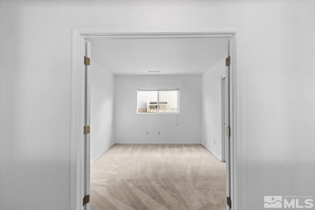 empty room with carpet and baseboards