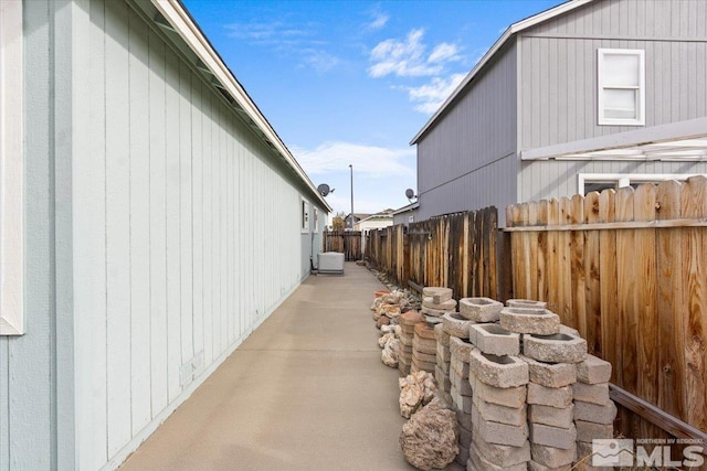 view of property exterior with fence and a patio