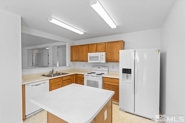 kitchen featuring light floors, light countertops, brown cabinetry, a sink, and white appliances