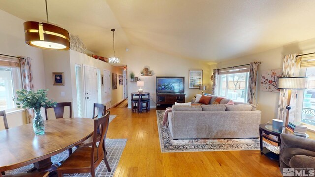 dining space with light wood-type flooring and vaulted ceiling