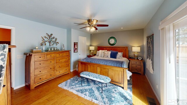 bedroom featuring a ceiling fan, wood finished floors, visible vents, and baseboards