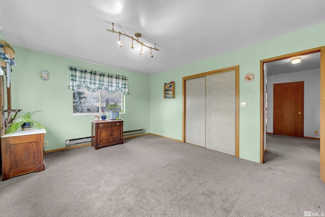 carpeted bedroom with a baseboard heating unit and a closet