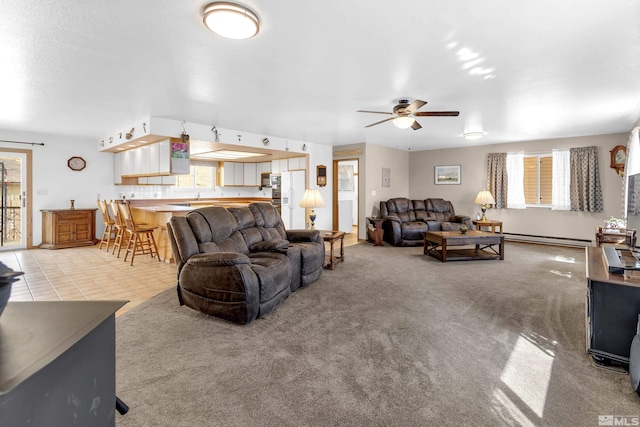 carpeted living area with a ceiling fan, tile patterned flooring, and baseboard heating