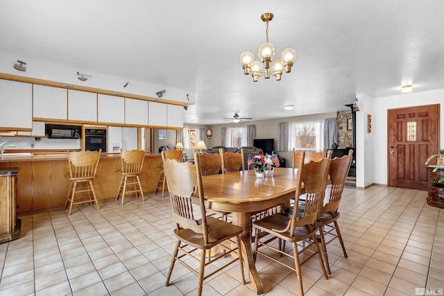 dining area featuring ceiling fan with notable chandelier and light tile patterned flooring