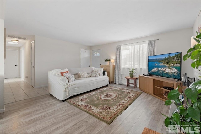 living area featuring light wood-style floors and visible vents