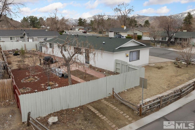 view of yard with a mountain view, a fenced backyard, and a residential view