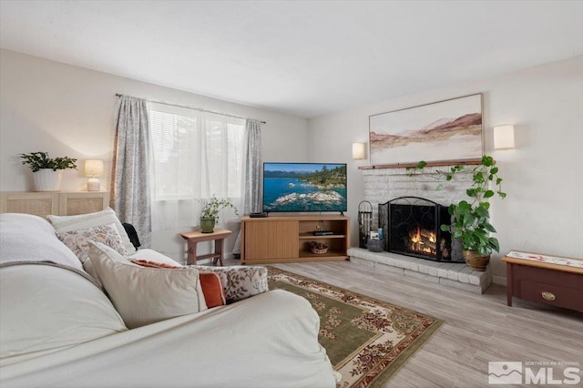 living area featuring a brick fireplace and wood finished floors