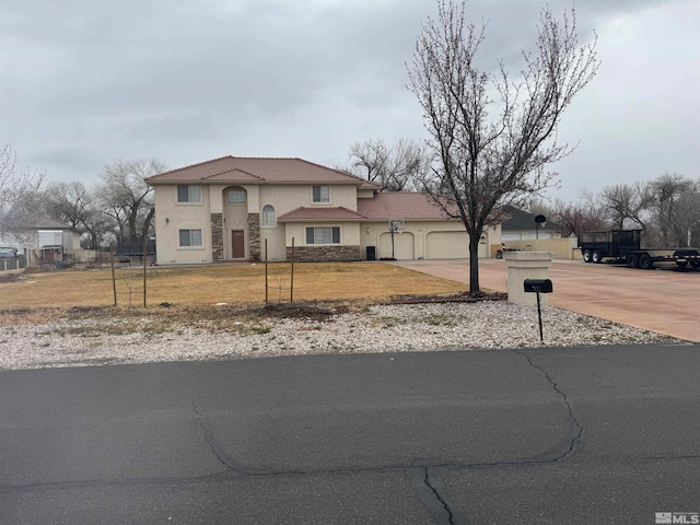 view of front of property with a front lawn, concrete driveway, stucco siding, stone siding, and an attached garage