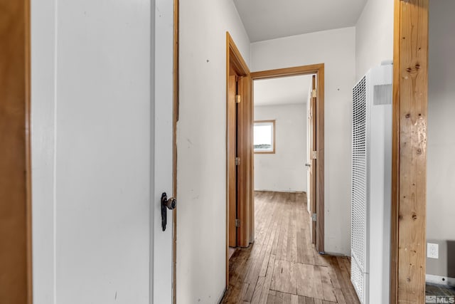 hallway with a heating unit and light wood finished floors