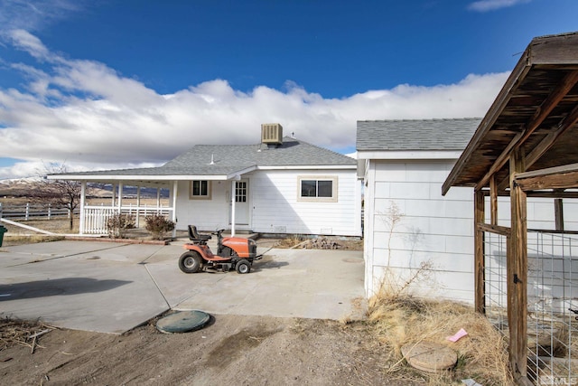 rear view of property featuring a patio area, roof with shingles, and central air condition unit