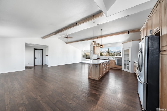 kitchen featuring dark wood-style flooring, a ceiling fan, freestanding refrigerator, open floor plan, and a kitchen bar