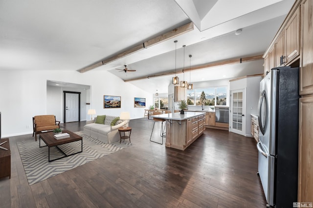 kitchen featuring dark wood-style flooring, a breakfast bar area, lofted ceiling with beams, freestanding refrigerator, and open floor plan