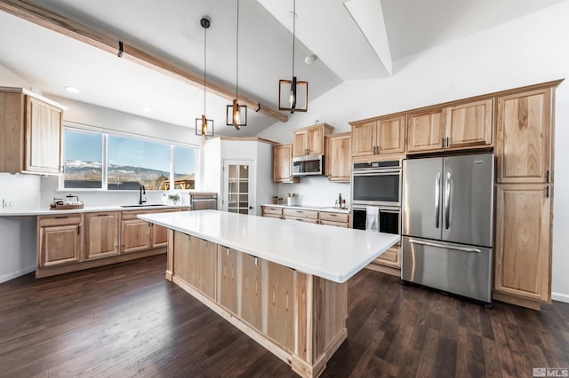 kitchen with light brown cabinetry, appliances with stainless steel finishes, a sink, and light countertops