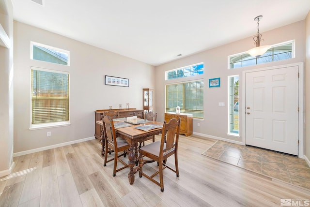 dining room with baseboards and light wood finished floors