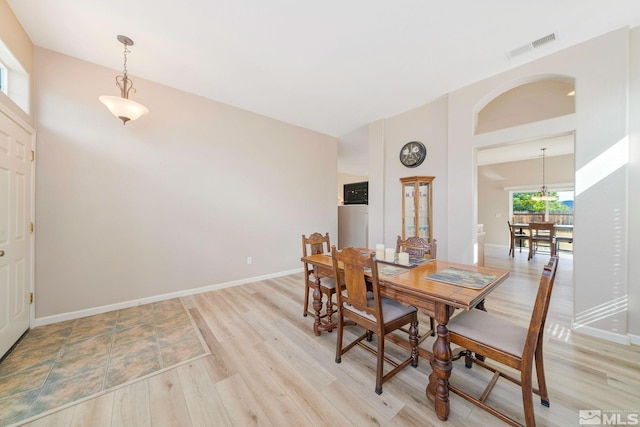 dining area with visible vents, light wood-style flooring, and baseboards