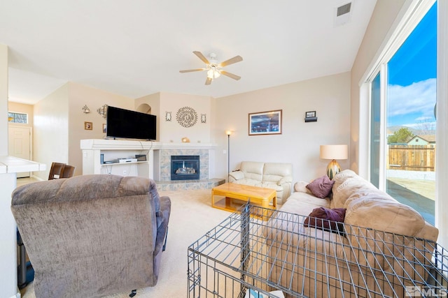 living area with carpet floors, ceiling fan, a fireplace, and visible vents