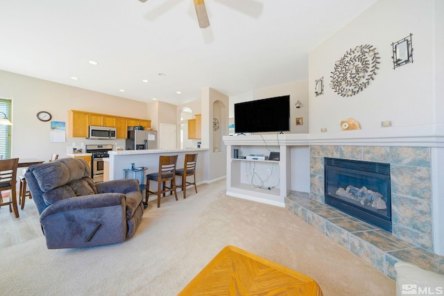 living area with a fireplace, recessed lighting, light carpet, ceiling fan, and baseboards