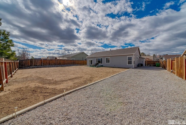 rear view of property with a fenced backyard and a patio