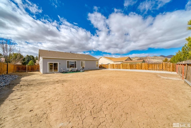 back of house featuring a fenced backyard and stucco siding