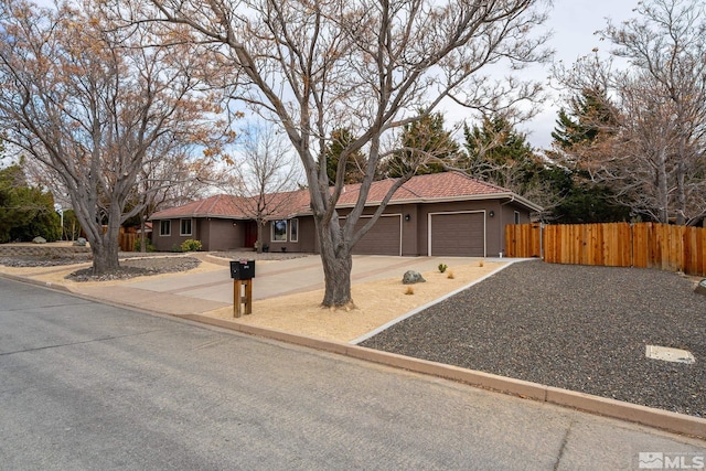 ranch-style home with a garage, fence, a tiled roof, driveway, and stucco siding