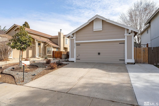 view of front of home featuring driveway, a garage, and fence