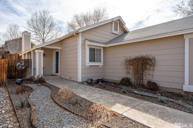 view of front of home with a shingled roof and fence