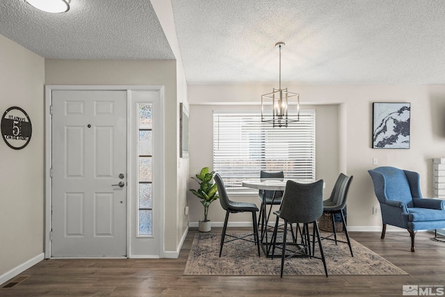 dining room featuring baseboards, plenty of natural light, wood finished floors, and a notable chandelier