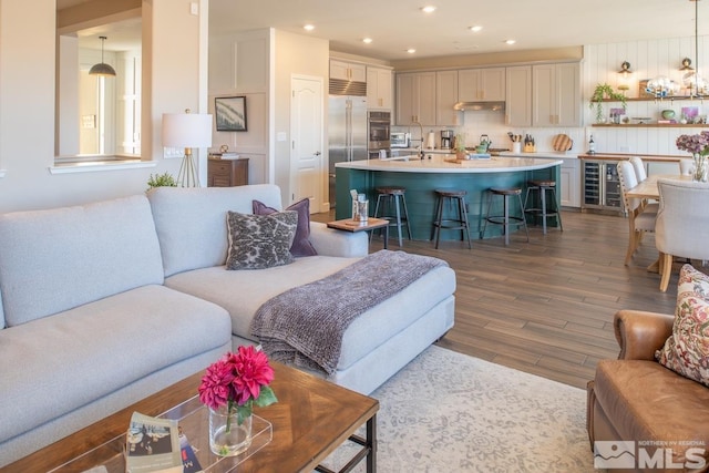 living room with dark wood-style floors, recessed lighting, and beverage cooler