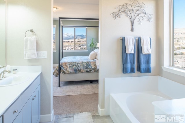 ensuite bathroom with vanity, a bath, and ensuite bathroom