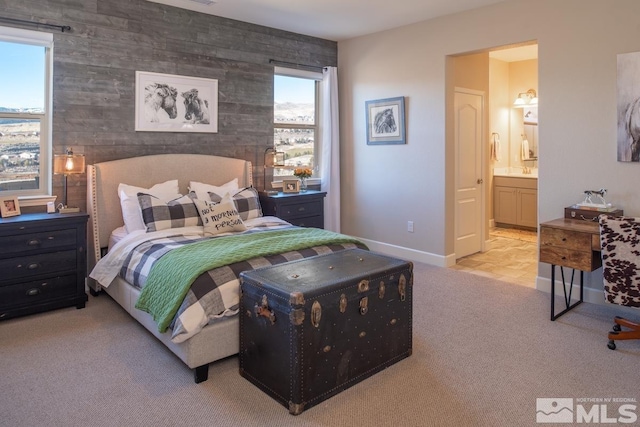 carpeted bedroom featuring baseboards and ensuite bathroom