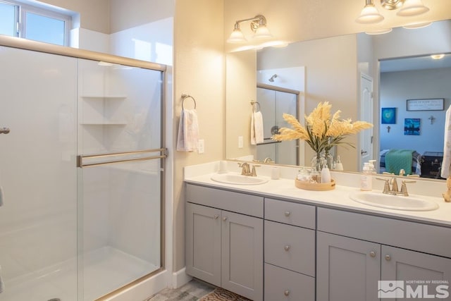 full bathroom featuring a stall shower, a sink, and ensuite bathroom