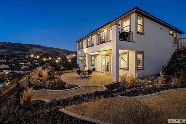 rear view of house featuring a patio area, fence, and stucco siding