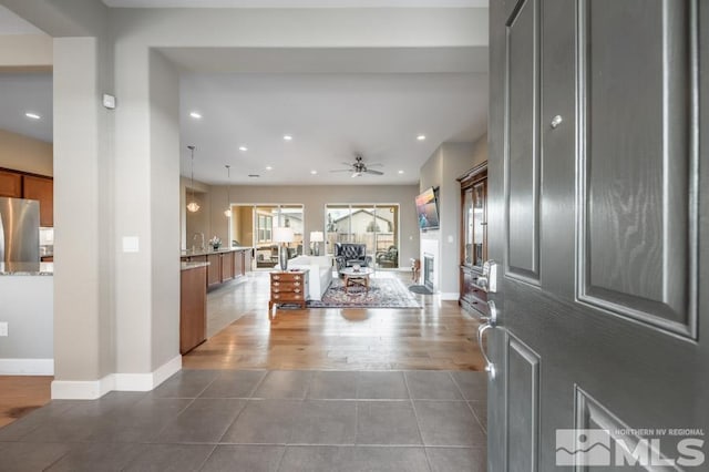 foyer featuring baseboards, dark tile patterned flooring, a ceiling fan, and recessed lighting