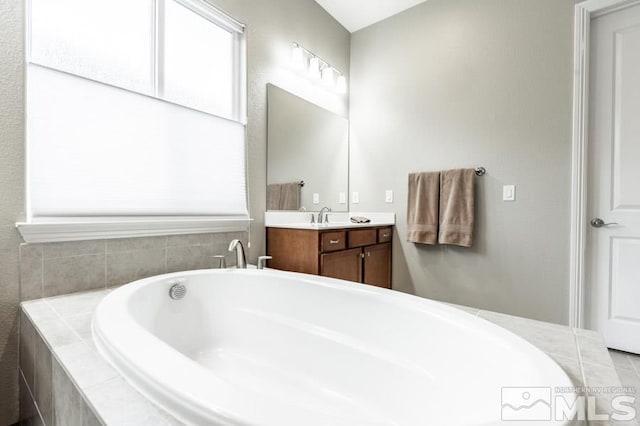 full bath featuring vanity and a bathtub