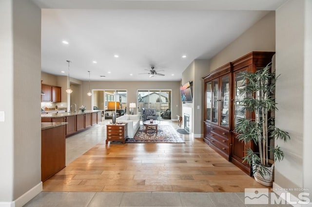 living room with light wood-style floors, recessed lighting, ceiling fan, and baseboards