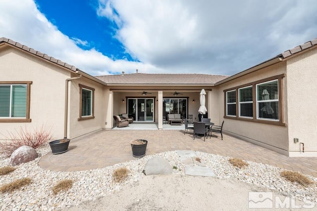 rear view of house featuring ceiling fan, a patio, and stucco siding