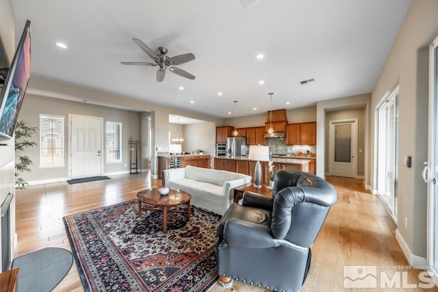 living area with a ceiling fan, light wood-type flooring, visible vents, and recessed lighting