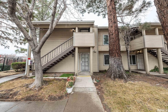 view of property with stairway and fence